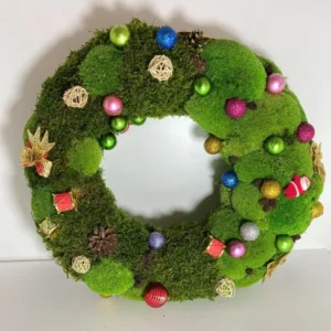 Weihnachtskranz aus Moos mit verschiedenen weihnachtlichen Dekorationselementen auf hellem Hintergrund.