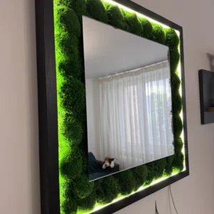 Bočný pohľad na zrkadlo Ekomoss s objemným zeleným machom. LED osvetlenie zvýrazňuje textúru guľôčkového machu v čiernom ráme.